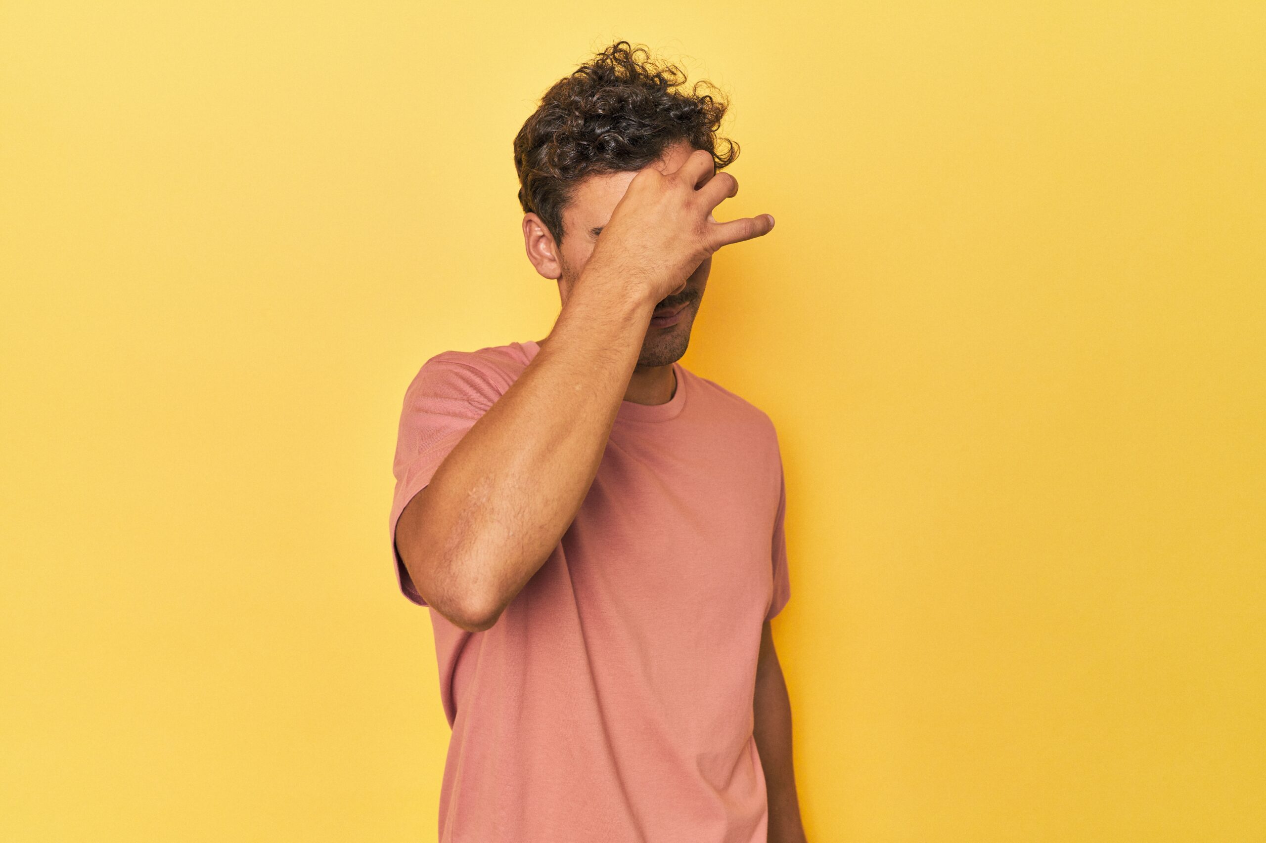 Person touching their forehead in discomfort, illustrating pain related to frontal headache causes.