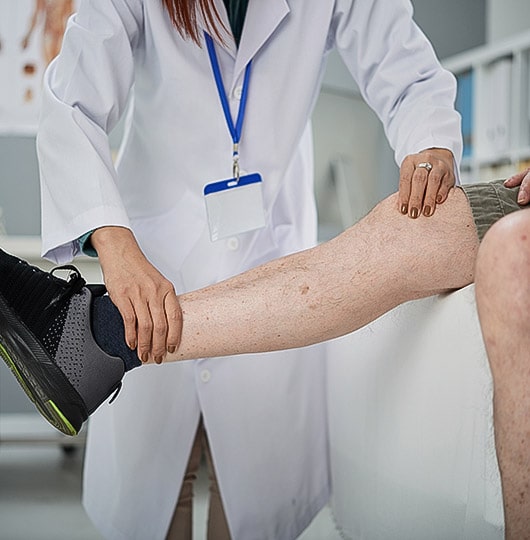 Vascular 2 Doctor examining the veins on a patient’s leg.